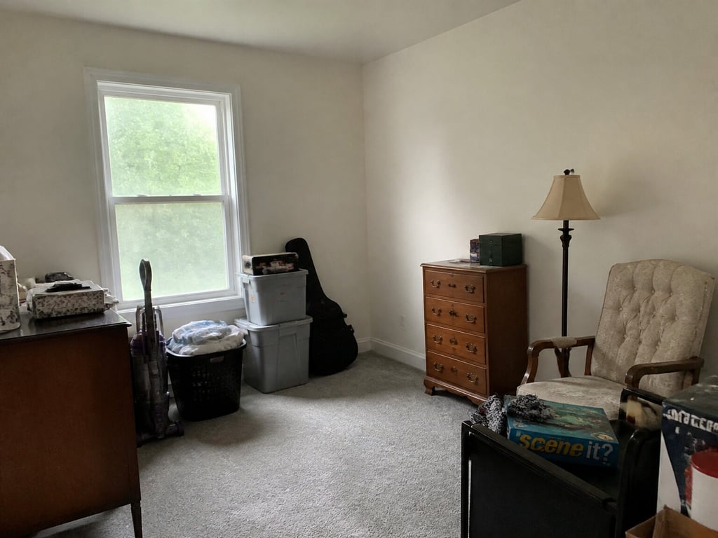 A cluttered spare room re-furnished as a home office. — before